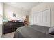 This bedroom is decorated with neutral wall paint and carpet plus a dresser full of shoes at 8990 Ace Loop, Champions Gate, FL 33896