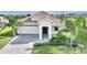 Charming home boasts a tile roof, brick paver driveway, two-car garage, and lush tropical landscaping at 8990 Ace Loop, Champions Gate, FL 33896