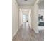 Bright hallway featuring wood-look tile flooring and views of the dining and bedroom at 8990 Ace Loop, Champions Gate, FL 33896