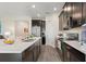Modern kitchen featuring dark cabinets, stainless steel appliances, and an island with a breakfast bar at 8990 Ace Loop, Champions Gate, FL 33896
