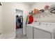 Clean, organized laundry room with shelving, folding area, washer, and dryer at 8990 Ace Loop, Champions Gate, FL 33896
