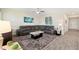 Nicely decorated living room showcasing neutral walls, ceiling fan, and dark grey sectional sofa at 8990 Ace Loop, Champions Gate, FL 33896