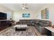 Spacious living room features a sectional sofa, large TV, ceiling fan and stylish decor at 8990 Ace Loop, Champions Gate, FL 33896