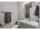 Bathroom featuring vanity with a grey cabinet and a large mirror at 11603 Malverns Loop, Orlando, FL 32832