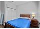 Cozy bedroom featuring a full-sized bed, nightstand with lamp, and a double-door closet at 11603 Malverns Loop, Orlando, FL 32832