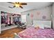Bedroom featuring wood floors, single bed and closet with clothes at 11603 Malverns Loop, Orlando, FL 32832