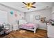 Bright bedroom features wood floors, a ceiling fan, and playful decor at 11603 Malverns Loop, Orlando, FL 32832