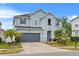 Charming two-story home with a gray exterior, well-manicured lawn, and attached two-car garage at 11603 Malverns Loop, Orlando, FL 32832