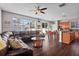 Open-concept living area with a large leather sectional, bright windows, and seamless flow to the kitchen at 11603 Malverns Loop, Orlando, FL 32832