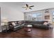 Comfortable living room featuring a large leather sectional, dark wood floors, and ample natural light at 11603 Malverns Loop, Orlando, FL 32832