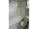 Bathroom featuring a bathtub with shower, white marble tiling, and toilet at 124 Cinnamon Dr, Orlando, FL 32825