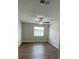 Bright bedroom featuring hardwood floors, ceiling fan, and a window letting in natural light at 124 Cinnamon Dr, Orlando, FL 32825