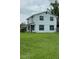 Rear view of a freshly painted two-story home with a spacious, green lawn at 124 Cinnamon Dr, Orlando, FL 32825