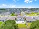 Aerial view showcases the backyard of the home with a patio and green lawn for outdoor activities at 1538 Mermaid Way, Haines City, FL 33844