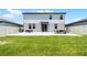 Backyard featuring a manicured lawn, stone patio, and a two-story home at 1538 Mermaid Way, Haines City, FL 33844