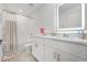 Bright bathroom featuring a white vanity, an LED mirror, and a shower-over-tub with a neutral shower curtain at 1538 Mermaid Way, Haines City, FL 33844