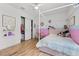 Cozy bedroom features a unique canopy bed, a playful pink color scheme, closet and stylish decor at 1538 Mermaid Way, Haines City, FL 33844