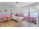 Spacious bedroom features a unique canopy bed, a playful pink color scheme, and large windows for natural light at 1538 Mermaid Way, Haines City, FL 33844
