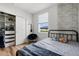 Bright bedroom featuring a full bed, a gray brick wall accent, and closet storage at 1538 Mermaid Way, Haines City, FL 33844