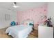 Stylish bedroom featuring a playful pink wallpaper, a cozy hanging chair, and a well-lit desk area at 1538 Mermaid Way, Haines City, FL 33844