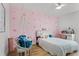 Charming bedroom features playful pink wallpaper, a cozy hanging chair, and stylish decor for a whimsical retreat at 1538 Mermaid Way, Haines City, FL 33844