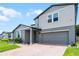 Charming two-story home with light-blue shutters, attached garage, and brick paver driveway at 1538 Mermaid Way, Haines City, FL 33844