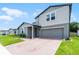 Charming two-story home with light-blue shutters, attached garage, and brick paver driveway at 1538 Mermaid Way, Haines City, FL 33844