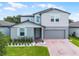 Charming two-story home with light-blue shutters, attached garage, and well-manicured lawn at 1538 Mermaid Way, Haines City, FL 33844