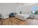 This bright main bedroom features wood floors, neutral walls, accent furniture, and natural light at 1538 Mermaid Way, Haines City, FL 33844