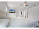 This bright main bedroom features wood floors, neutral walls, ceiling fan, and a mounted television at 1538 Mermaid Way, Haines City, FL 33844