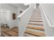 Bright staircase with wood treads, white risers, and view of bathroom with tub and shower at 1538 Mermaid Way, Haines City, FL 33844