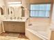 Inviting bathroom featuring dual sinks, large soaking tub, and neutral color palette at 162 Seneca Point Trl, Kissimmee, FL 34746