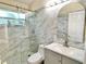 Modern bathroom features marble tile, glass shower, updated vanity with white countertop and sleek hardware at 162 Seneca Point Trl, Kissimmee, FL 34746