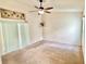 Spacious bedroom with a ceiling fan and carpet flooring with a butterfly art piece at 162 Seneca Point Trl, Kissimmee, FL 34746