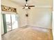 Bright bedroom with ceiling fan, carpet, and access to an outdoor seating area at 162 Seneca Point Trl, Kissimmee, FL 34746