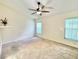 Spacious bedroom with vaulted ceiling, neutral carpet, large windows, and a ceiling fan with light at 162 Seneca Point Trl, Kissimmee, FL 34746