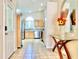 View of tiled entryway leading to kitchen, featuring glass table and decorative floral arrangement at 162 Seneca Point Trl, Kissimmee, FL 34746