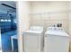 Bright laundry room with washer, dryer, and open shelving conveniently located near the garage at 162 Seneca Point Trl, Kissimmee, FL 34746