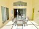 Covered patio with glass table and seating, connecting indoor/outdoor living spaces at 162 Seneca Point Trl, Kissimmee, FL 34746