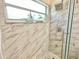 This walk-in shower offers marble tile, a window, a shower head, and a handheld at 162 Seneca Point Trl, Kissimmee, FL 34746