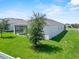 A view of the home's white exterior and well-maintained lawn at 1717 Hilltop Dr, Dundee, FL 33838