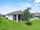 A view of the property's backyard, showcasing the screened-in porch and lush lawn at 1717 Hilltop Dr, Dundee, FL 33838