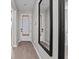 Bright hallway featuring wood-look floors, neutral walls, and a large decorative mirror at 1717 Hilltop Dr, Dundee, FL 33838