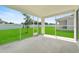 Covered, screened patio with concrete flooring, overlooks lush backyard and blue sky at 1717 Hilltop Dr, Dundee, FL 33838