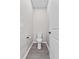 Toilet in a small room with hard flooring, door, and gray paint at 1717 Hilltop Dr, Dundee, FL 33838