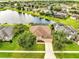 Beautiful aerial view of the home with a well manicured lawn near a tranquil pond and lush landscaping at 1902 Tumblewater Blvd, Ocoee, FL 34761