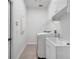 Clean and modern laundry room with tile floor, large sink, and front load washer and dryer at 1902 Tumblewater Blvd, Ocoee, FL 34761
