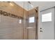 Tiled shower with glass door and decorative accent tiles at 1902 Tumblewater Blvd, Ocoee, FL 34761