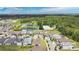 An aerial view of a neighborhood featuring a pond and wooded area in the background at 2009 Napoli Dr, St Cloud, FL 34771