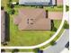 An aerial view of a house with a brown roof, green lawn, and brick driveway on a sunny day at 2009 Napoli Dr, St Cloud, FL 34771